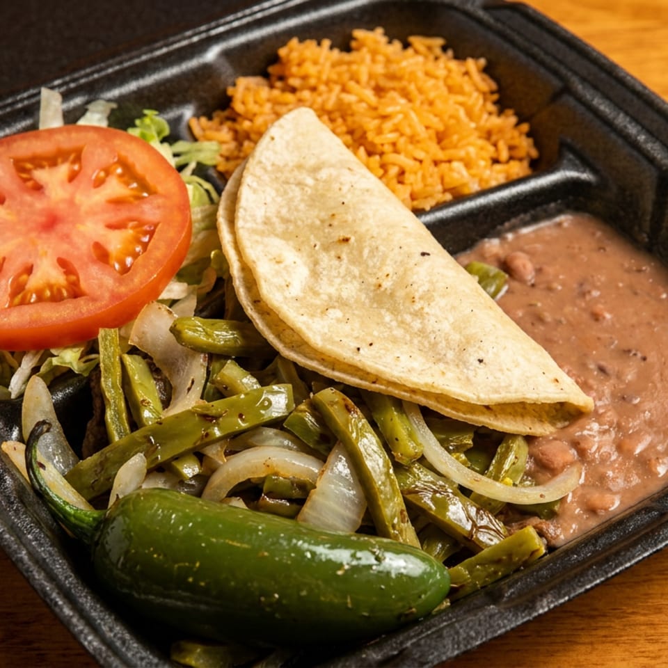 Black takeout container with a taco, rice, refried beans, nopales, tomato, lettuce, and a jalapeño.