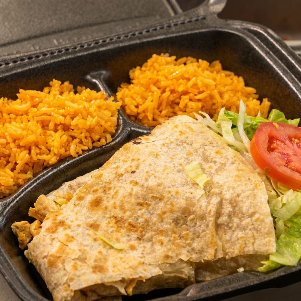 Quesadilla meal with Mexican rice, lettuce, and tomato in a black take-out container.