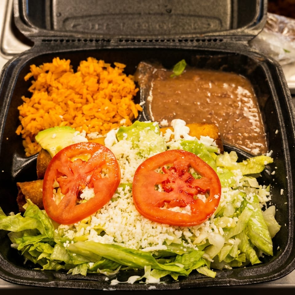 Mexican takeout meal with orange rice, refried beans, salad, tomatoes, cheese, avocado, and taquitos.